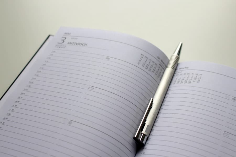 An open day planner with a pen resting on it